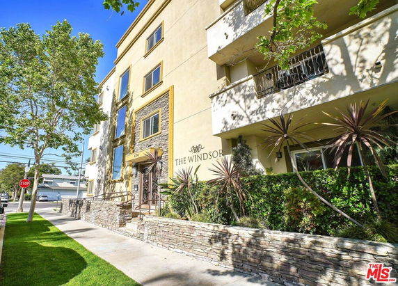 Front view of a multi-story building named 'The Windsor' with balconies and a brick entrance.