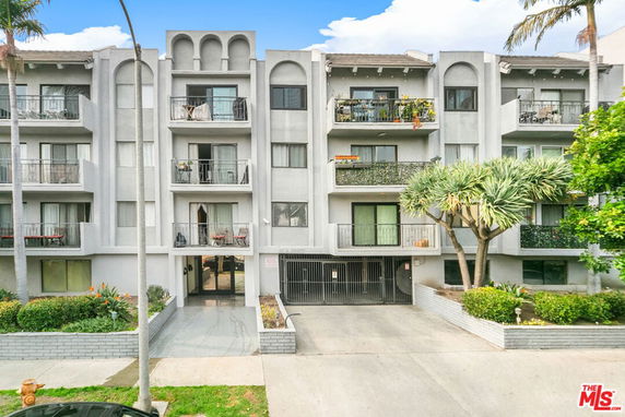 Front view of a multi-story apartment building with balconies.