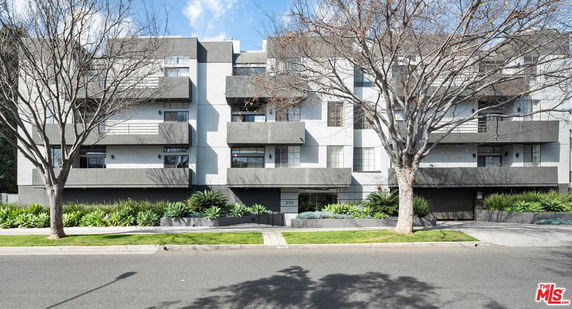 Front view of a multi-story apartment building with balconies.