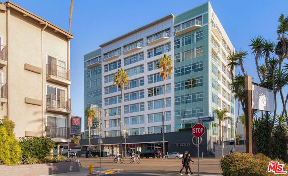 Front view of a multi-story building with large glass windows and a modern design.