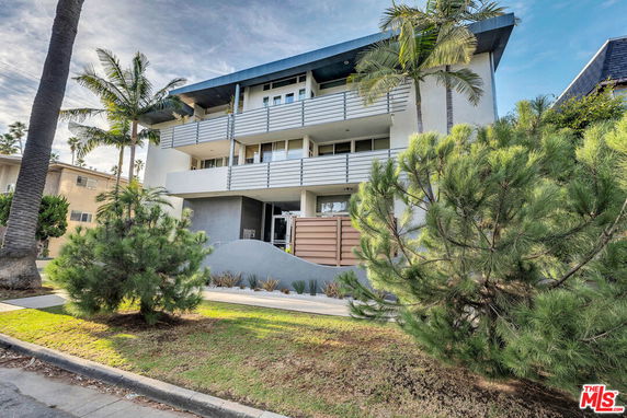 Front view of a multi-story building with balconies and modern design features.