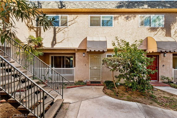 Front view of a two-story residential building with two entrance doors and small awnings.