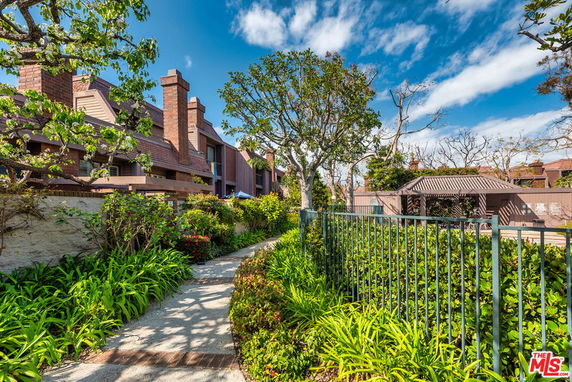Front view of a multi-story house with brick chimneys and a walkway.