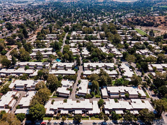 Panoramic view of a residential area with multiple uniform buildings and surrounding greenery.