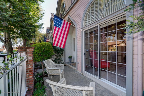 Front view of a multi-story house with decorative windows and an American flag displayed.