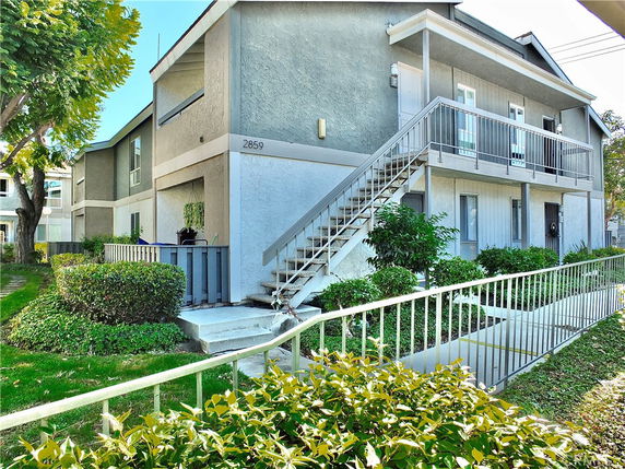 Front view of a two-story residential building with external staircase.