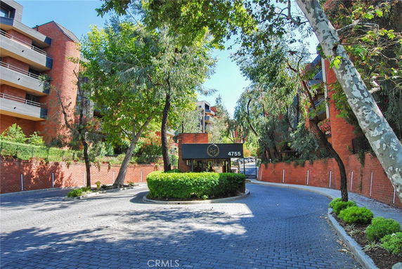 Front view of a multi-story brick apartment complex with balconies.