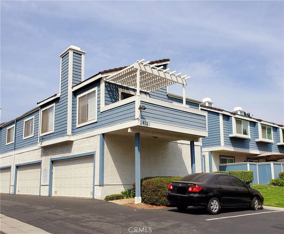 Front view of a two-story building with a garage and balcony.