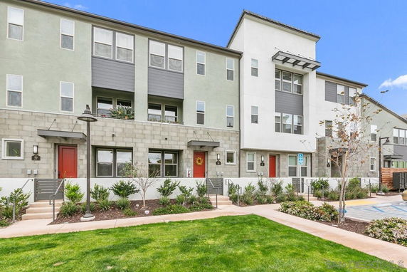 Front view of a multi-story residential building with multiple entrances and a modern design.