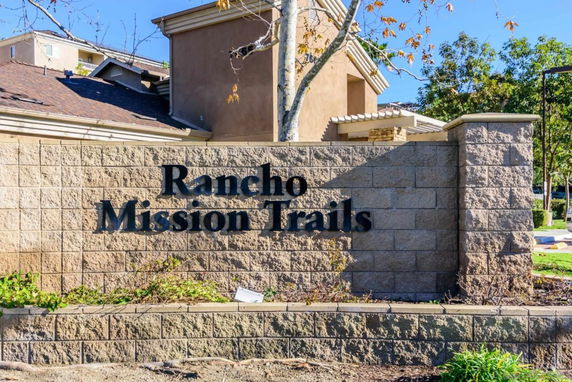 Front view of a building with a stone wall displaying the name Rancho Mission Trails.