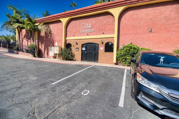 Front view of a building with a parking area and a car parked.