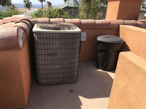 Rooftop area with an air conditioning unit and a trash bin.