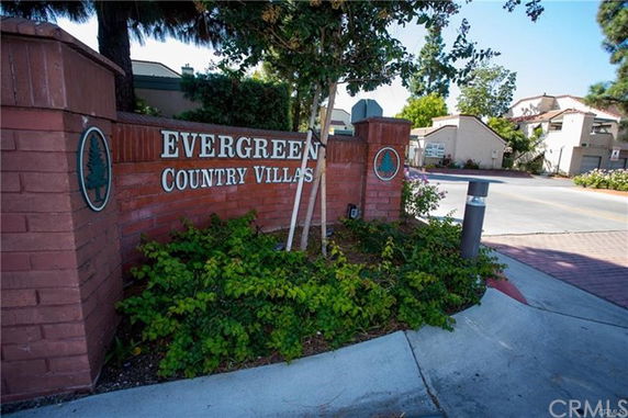Entrance view of a residential area with a sign for Evergreen Country Villas.
