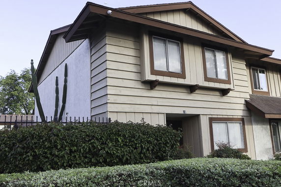 Front view of a two-story house with brown trim and siding.