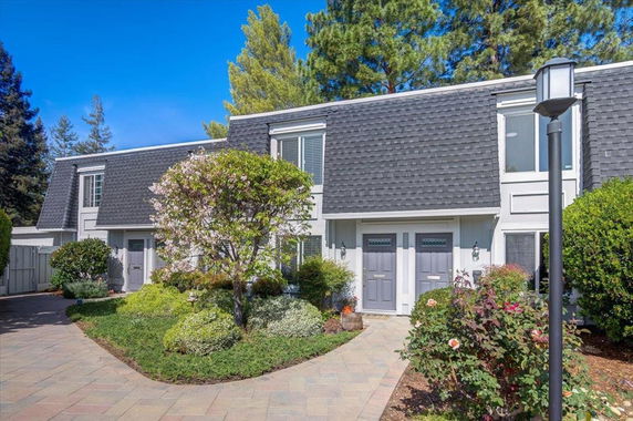 Front view of a two-story house with a shingled roof and two entrance doors.