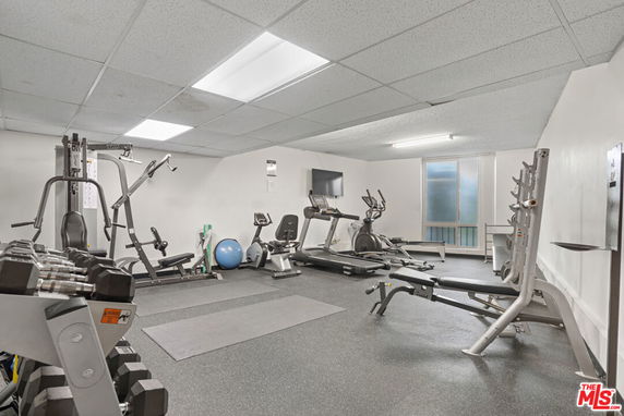 Indoor gym area with exercise equipment and weights.