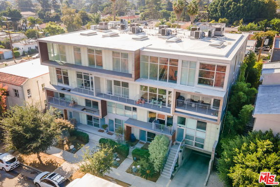 Front view of a modern multi-story building with large windows and balconies.