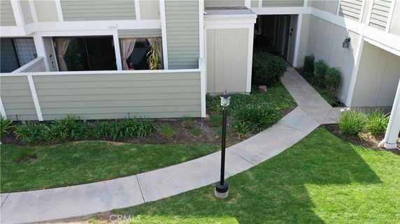 Exterior view of a residential building with green siding and a walkway.