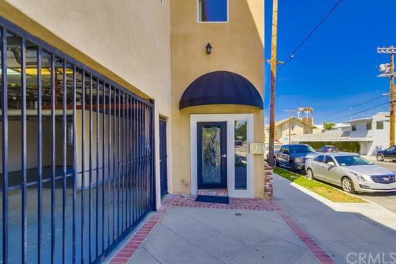 Front view of a building entrance with a glass door and black awning.