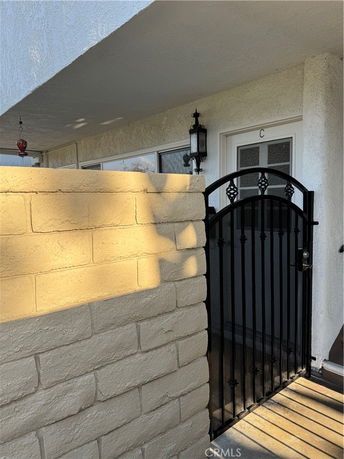 Entrance view of a building with a metal gate and a brick wall.