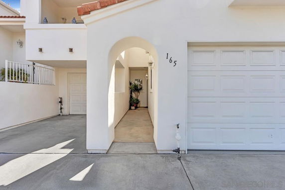 Front view of a house with an arched entryway and garage.