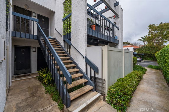 Front view of a multi-story residential building with stairs and balconies.