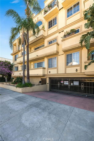 Front view of a multi-story building with balconies and gated garage.