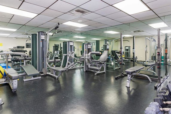 Gym area with various exercise machines and weights.