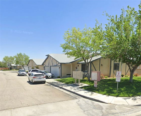 Front view of single-story houses with garages on a street.