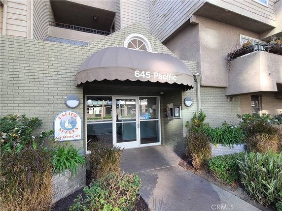 Front entrance of a building with awning and glass doors.