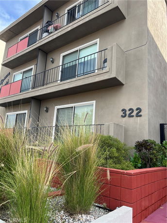Front view of a multi-story apartment building with balconies.