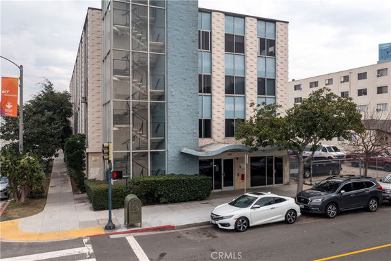 Front view of a multi-story building with a glass staircase enclosure.