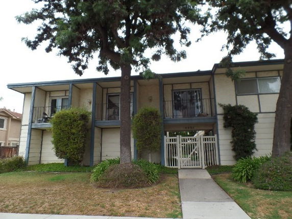 Front view of a two-story house with balconies and a central entrance walkway.