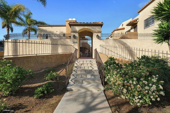 Front view of a house with a gated entry and stucco exterior.