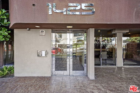 Front view of a building entrance with large glass doors and the number 1425 displayed above.
