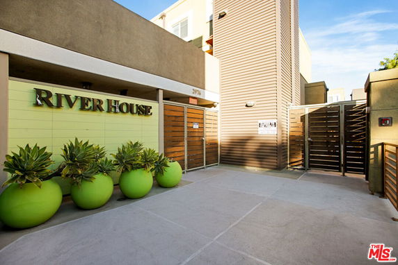 Front view of a modern building entrance with green planters.