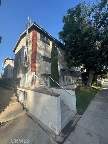 Front view of a two-story building with a staircase and railing.