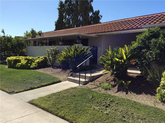 Front view of a single-story house with a tiled roof and garden.