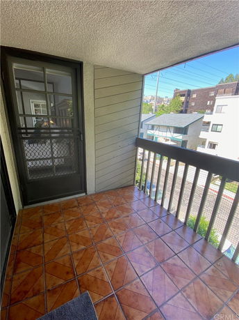 Balcony view with tiled floor overlooking surrounding buildings.