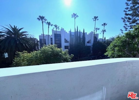View of surrounding area with palm trees and a distant building seen from a high vantage point.