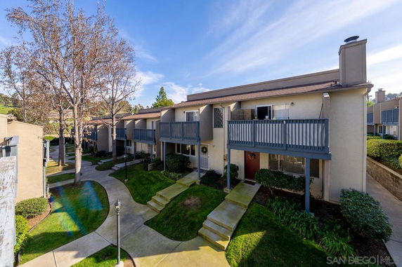 Front view of a two-story residential building with balconies and a walkway.