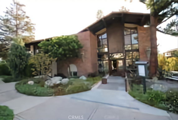 Front view of a modern house with large glass windows and a peaked roof.