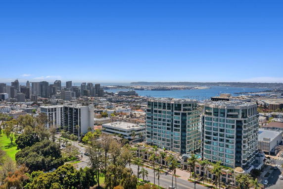 Panoramic view of a city skyline with buildings and waterfront.