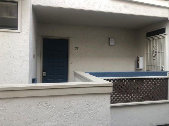 Front view of a residential building with a blue door and decorative railing.