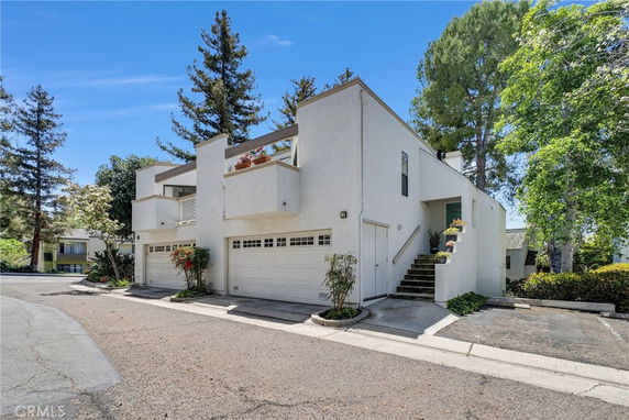 Front view of a modern multi-level house with white exterior and a double garage.