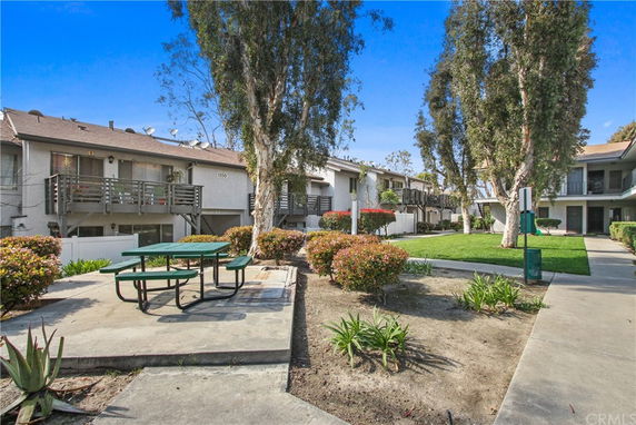 Front view of a multi-unit residential building with balconies and a picnic area.