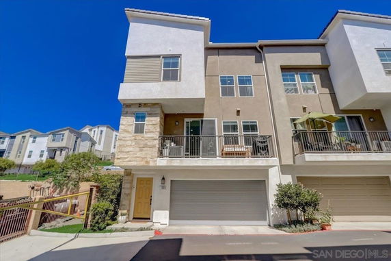 Front view of a multi-story townhouse with balconies and a double garage.
