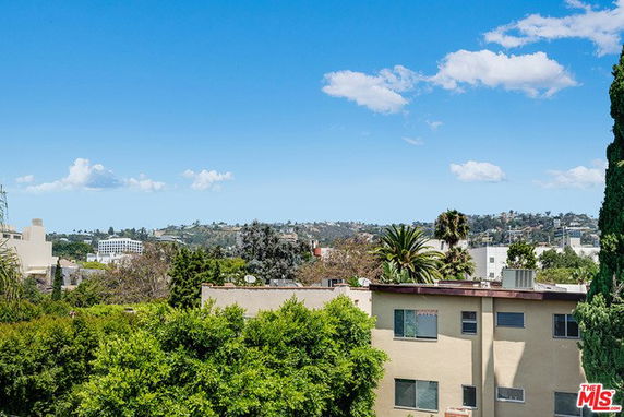 Panoramic view of surrounding areas with buildings and greenery under a clear blue sky.