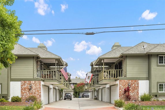 Front view of a two-story residential building with balconies and garages.