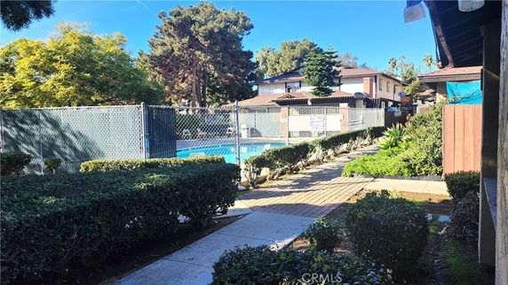 Outdoor area with a swimming pool surrounded by a fence.
